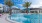 a pool with palm trees and buildings in the background
