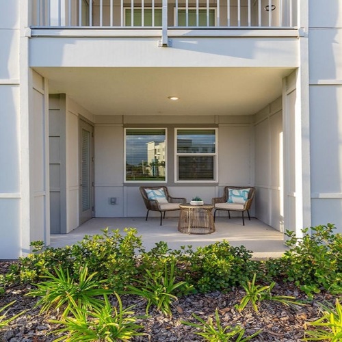 a patio with chairs and tables outside a building