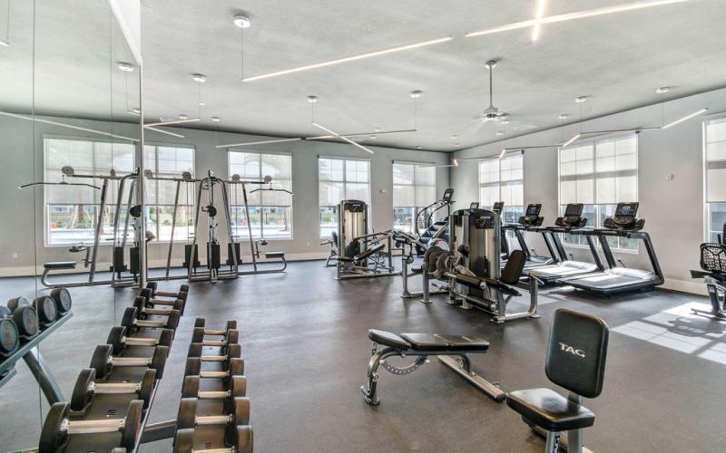 a room with exercise equipment and chairs
